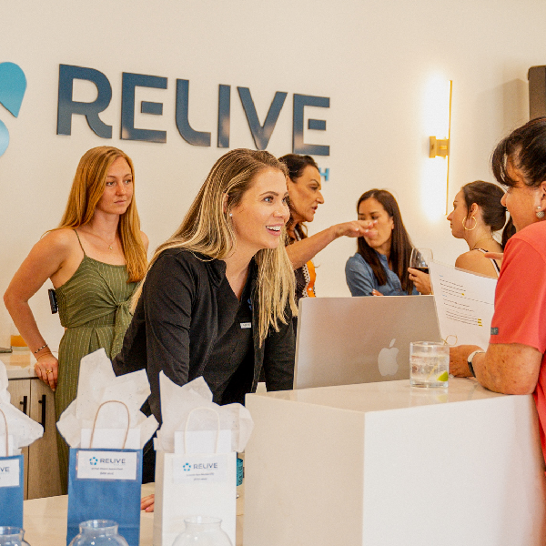 Relive Health Hendersonville Med Spa Lobby with female employee speaking with customer 1 600x600 1